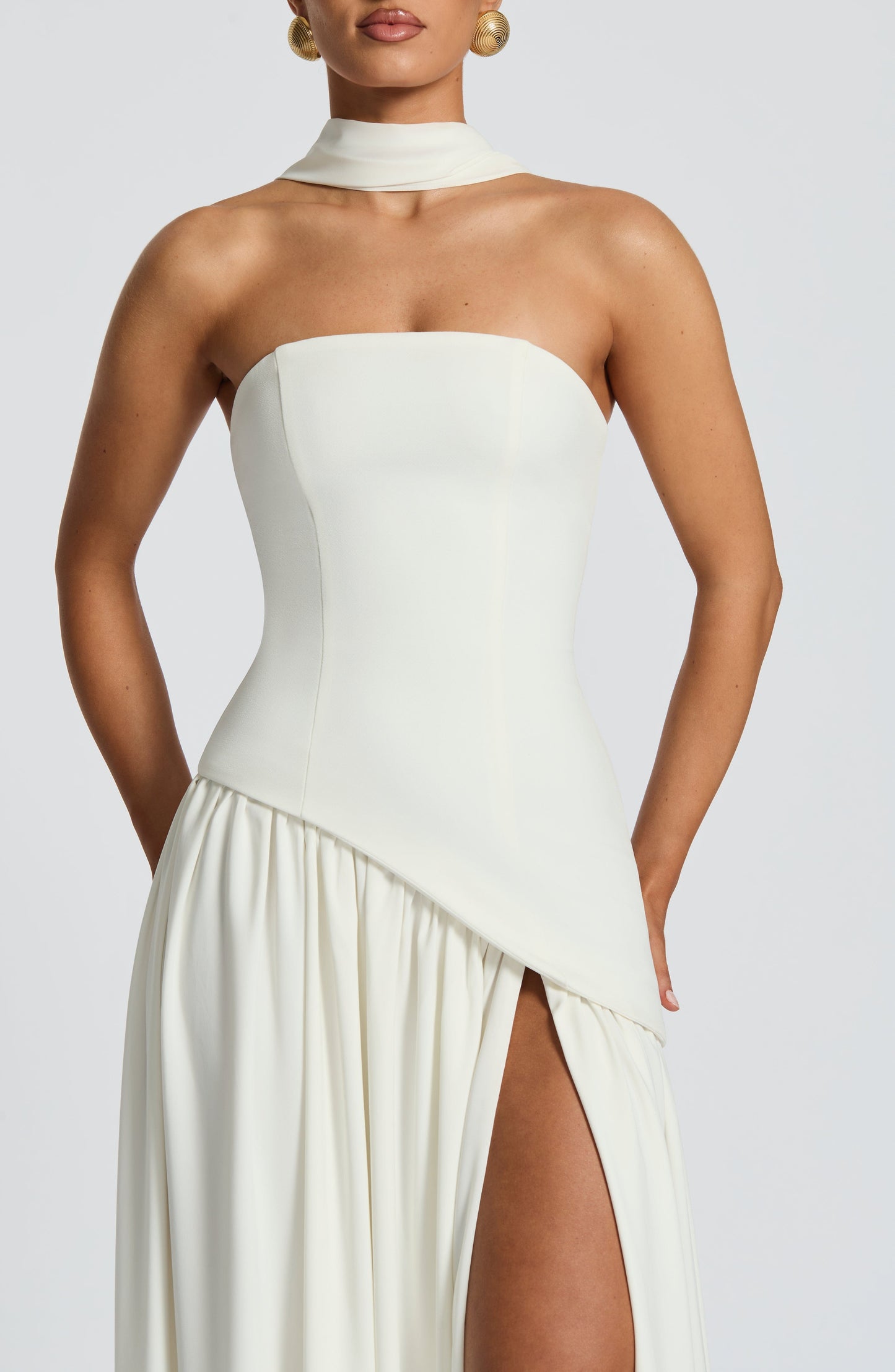 White strapless satin maxi dress with high slit and sculpted waist in details